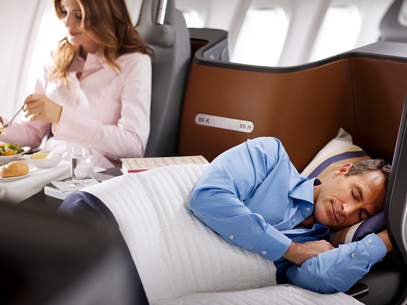 man sleeping in business class travel